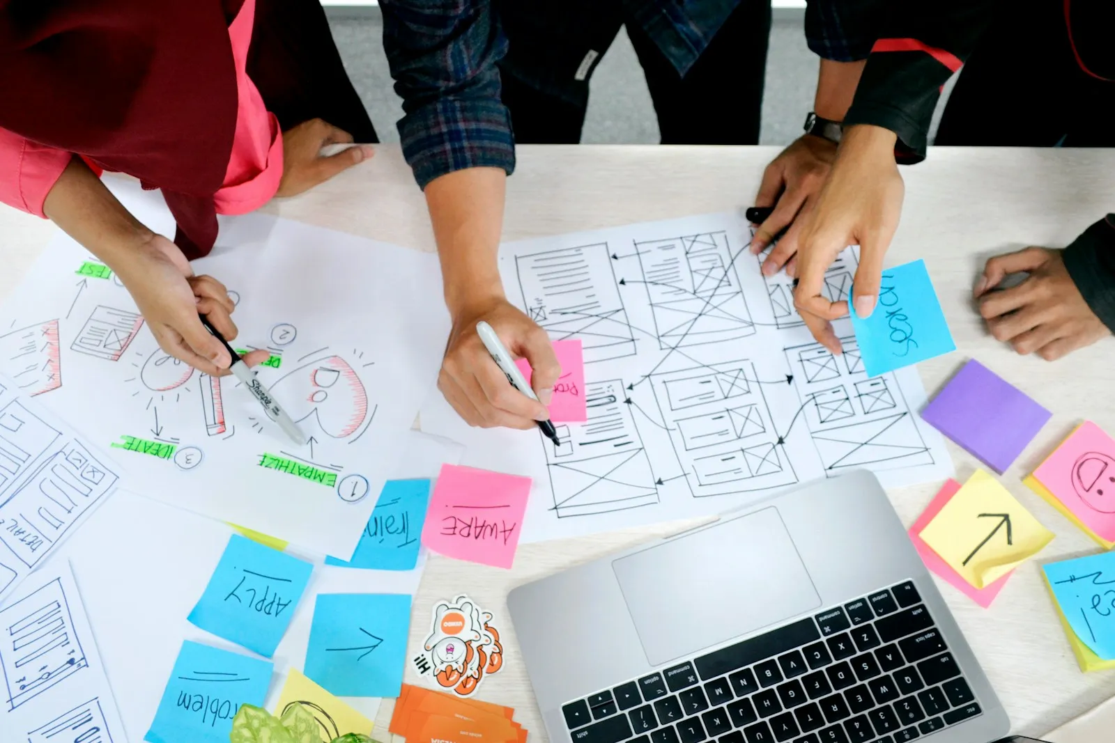 Marketing planning workshop with a team reviewing strategy notes around a table.
