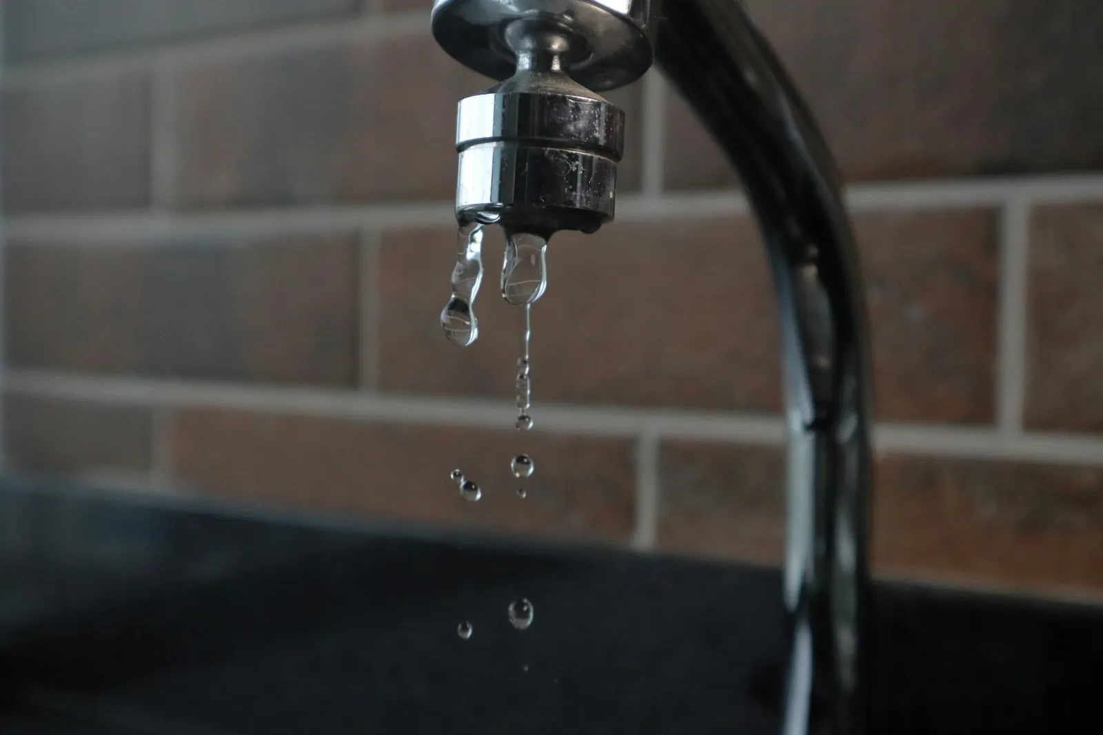 Water dripping from a faucet, used as a visual metaphor for wasted ad spend.